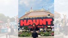 Visitors walking through the spooky entrance gate at Dorney Park Halloween Haunt surrounded by fog, scare actors, and themed attractions.