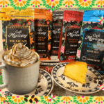 Taza artesanal de cacao latte con vapor, sobre mesa rústica adornada con flores de cempasúchil, símbolo del otoño y la conexión ritual con la gratitud.