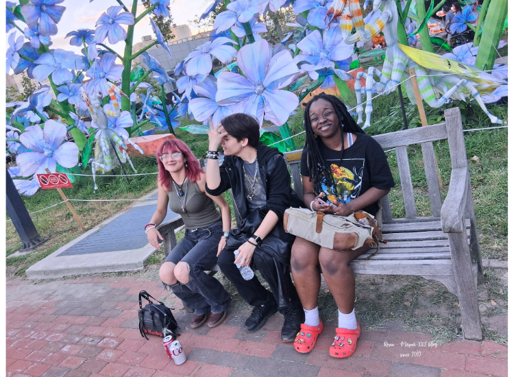 Sarah y sus amigas posando alegremente en un banco durante su visita nocturna al Philadelphia Chinese Lantern Festival en Franklin Square.
